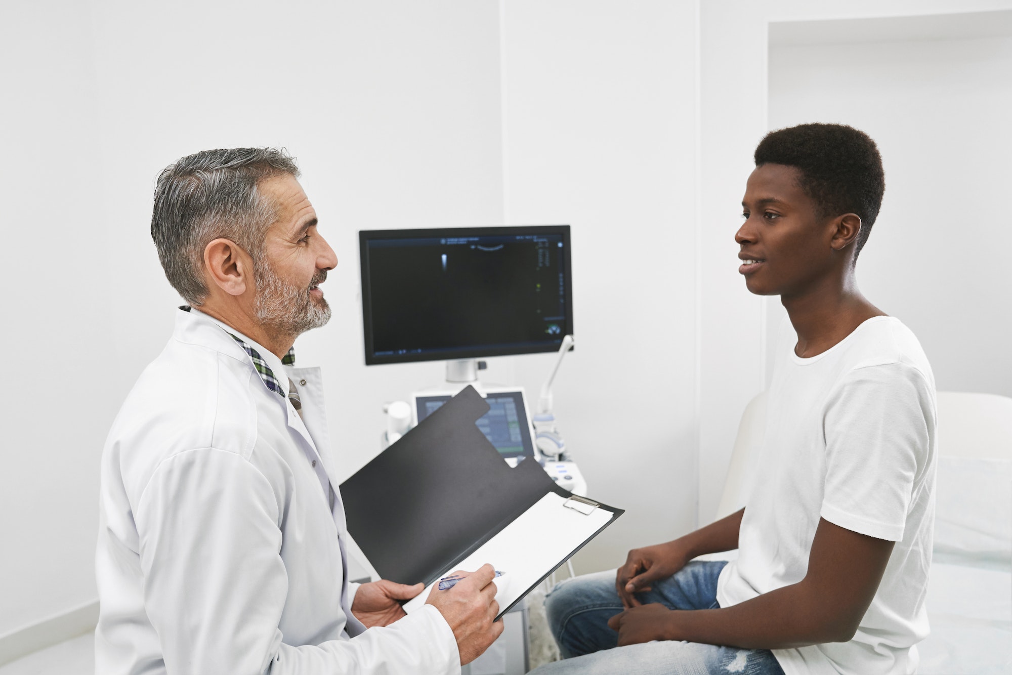 African patient consulting with doctor in cabinet